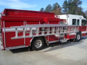 Mounted above the passenger side body is a hydraulic ladder rack that carries a 28' extension ladder, two 16' roof ladders, one 10' attic ladder and storage for three pike poles of various lengths