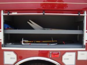This compartment provides long-handled tools for firefighters to use on incidents.  Below the compartment in the silver doors are extra SCBA bottles for firefighters to switch out their empty bottles.
